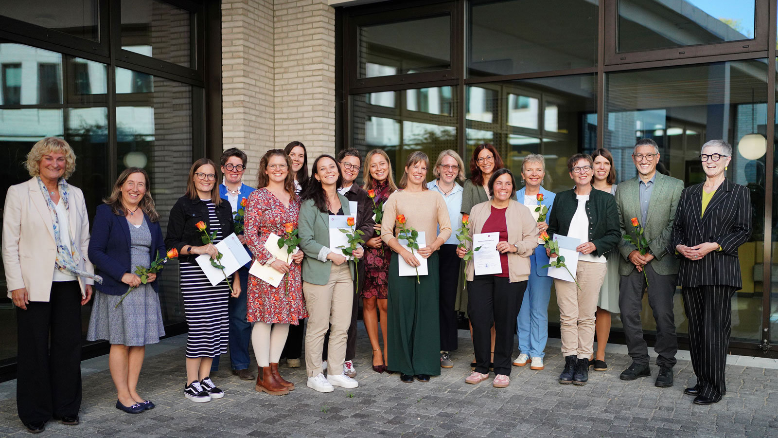 Eine Gruppe von hauptsächlich Frauen steht nebeneinander und lächelt in die Kamera.