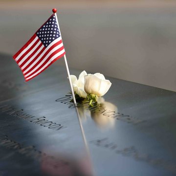 Die Aufnahme zeigt eine weiße Rose und eine US-Flagge an der Gedenkstätte für die Opfer vom 11. September.