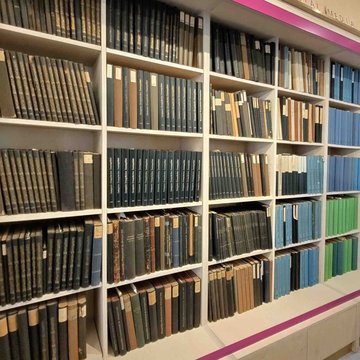Ein Bücherregal mit großen Bücherbänden in verschiedenen Farben.