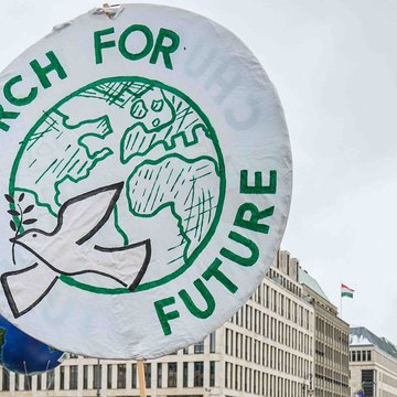 Aktivistinnen und Aktivisten halten ein Schild hoch auf dem steht "Church for Future"