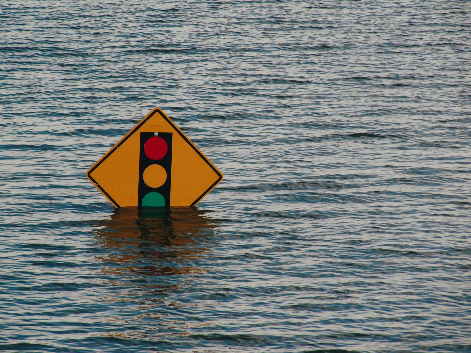 Der untere Teil eines Ampelschilds steht unter Wasser