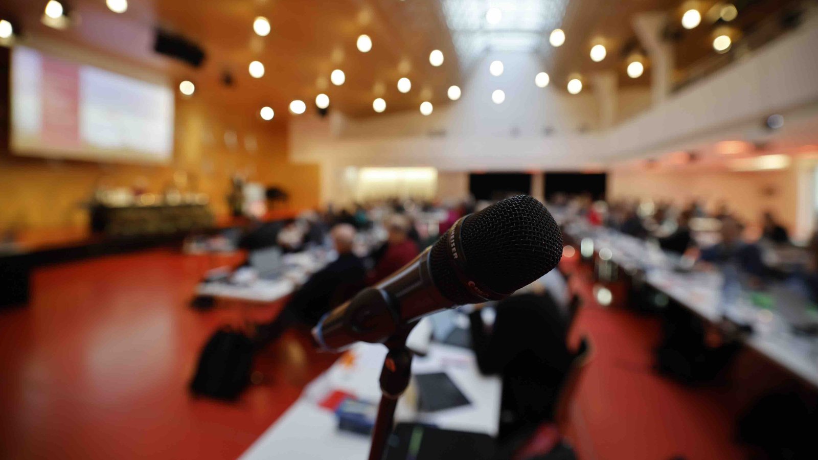Mikrofon im Vordergrund, Kirchenparlament der Evangelischen Landeskirche im Hintergrund