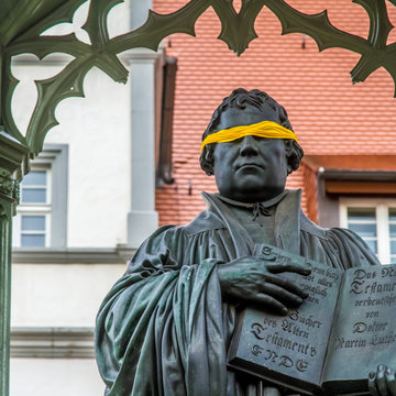 Statue von Martin Luther mit gelber Augenbinde