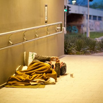 Obdachloser liegt in einer Unterführung auf dem Boden
