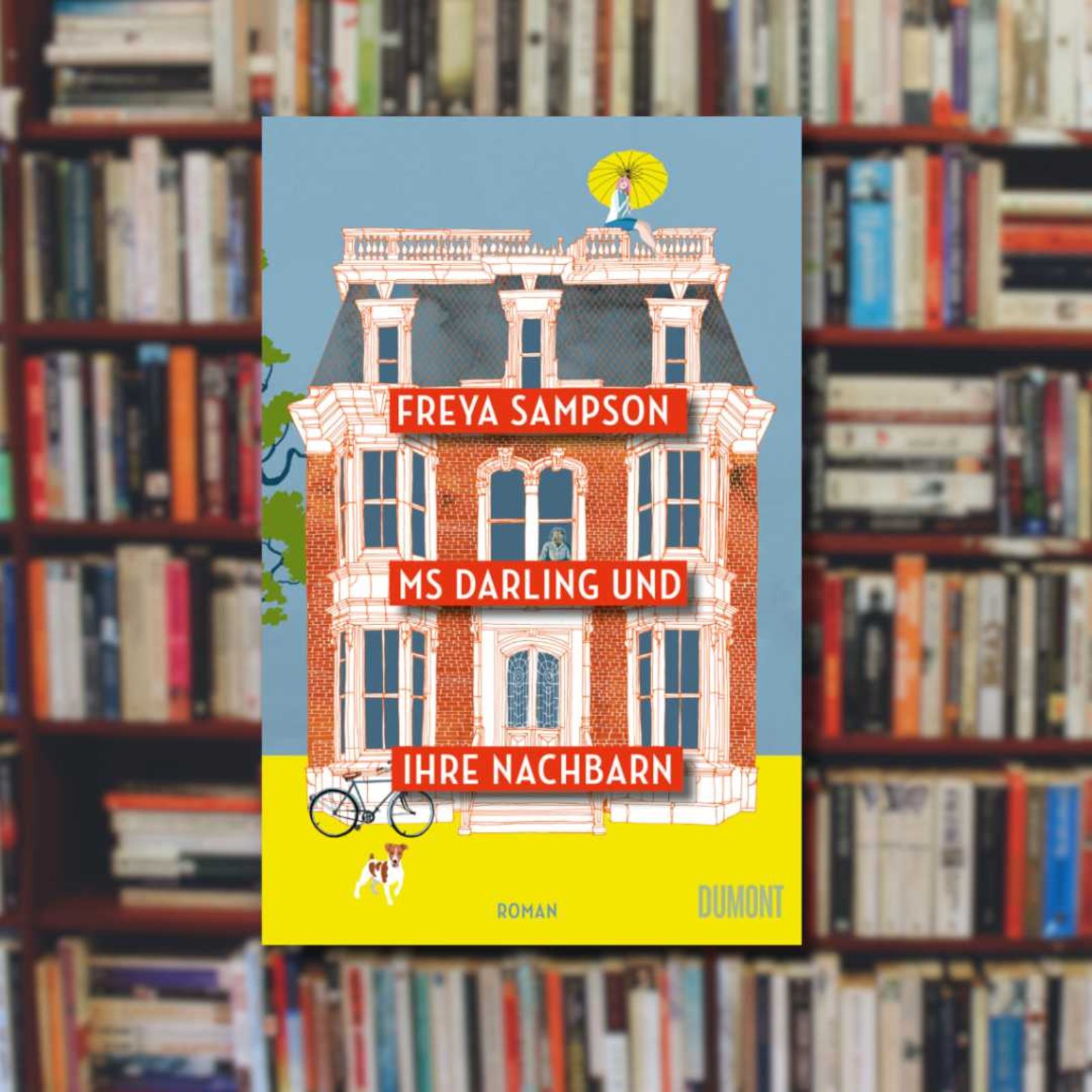 Buchcover „Ms Darling und ihre Nachbarn” von Freya Sampson im Vordergrund. Ein Bücherregal im Hintergrund.