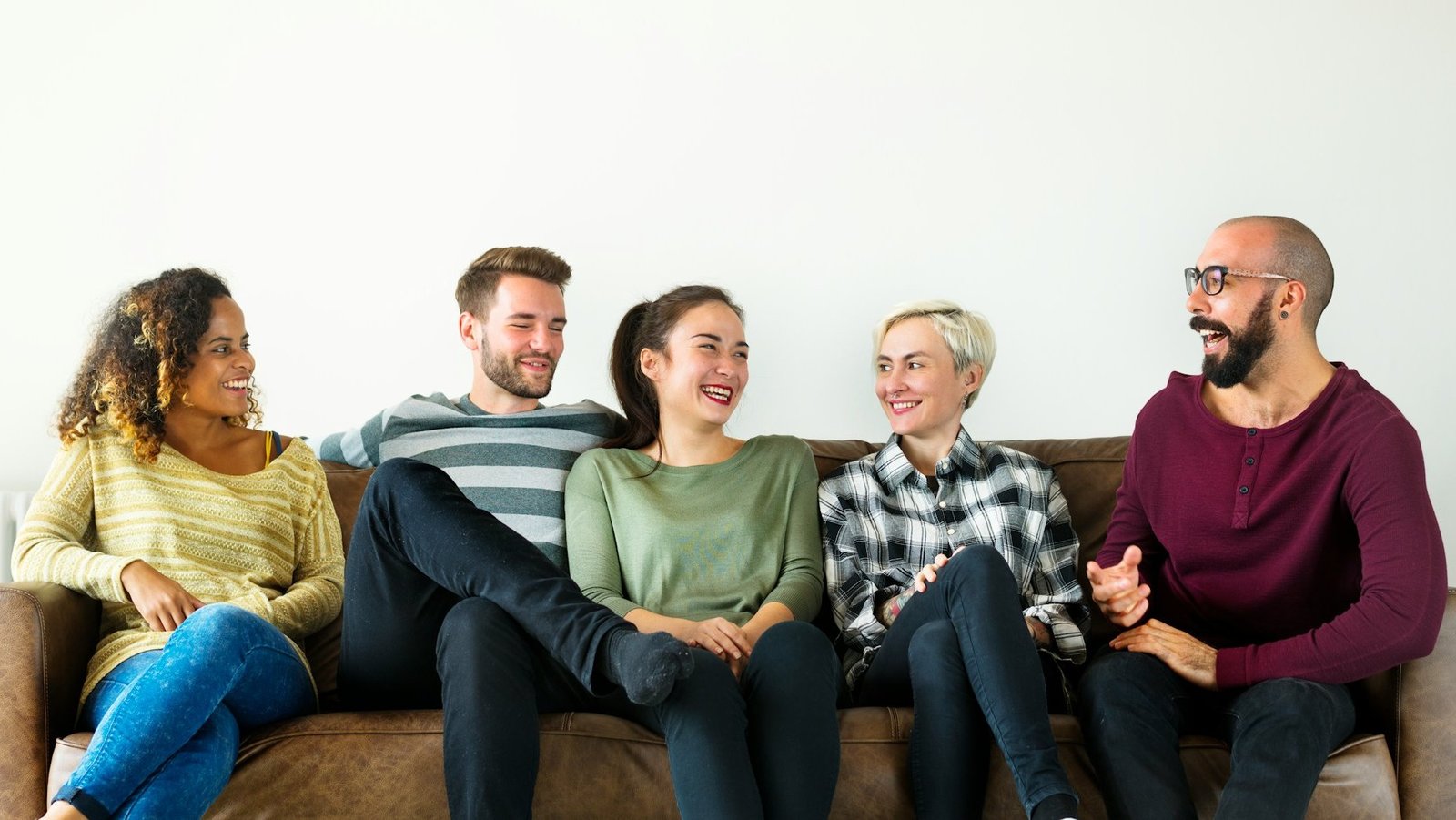 Alte und junge Menschen, die zusammen auf einem Sofa sitzen