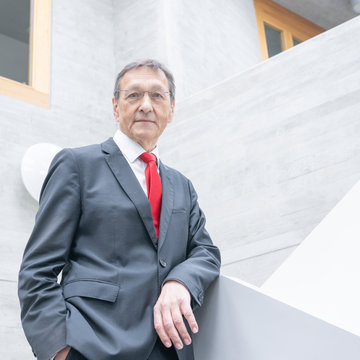 Norbert Collmar steht in einem grauen Treppenhaus