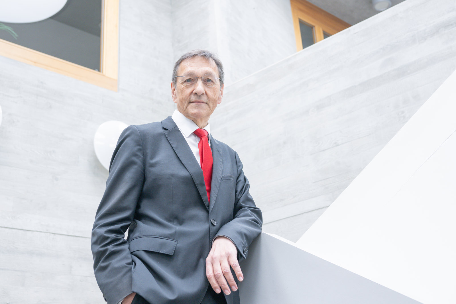Norbert Collmar steht in einem grauen Treppenhaus