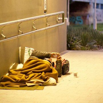 Obdachloser liegt in einer Unterführung auf dem Boden