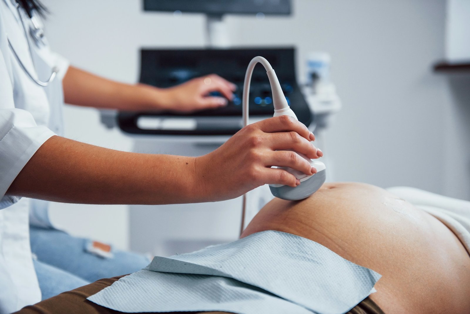 Der Bauch einer Schwangeren wird von einer Ärztin mit einem Ultraschallgerät untersucht.