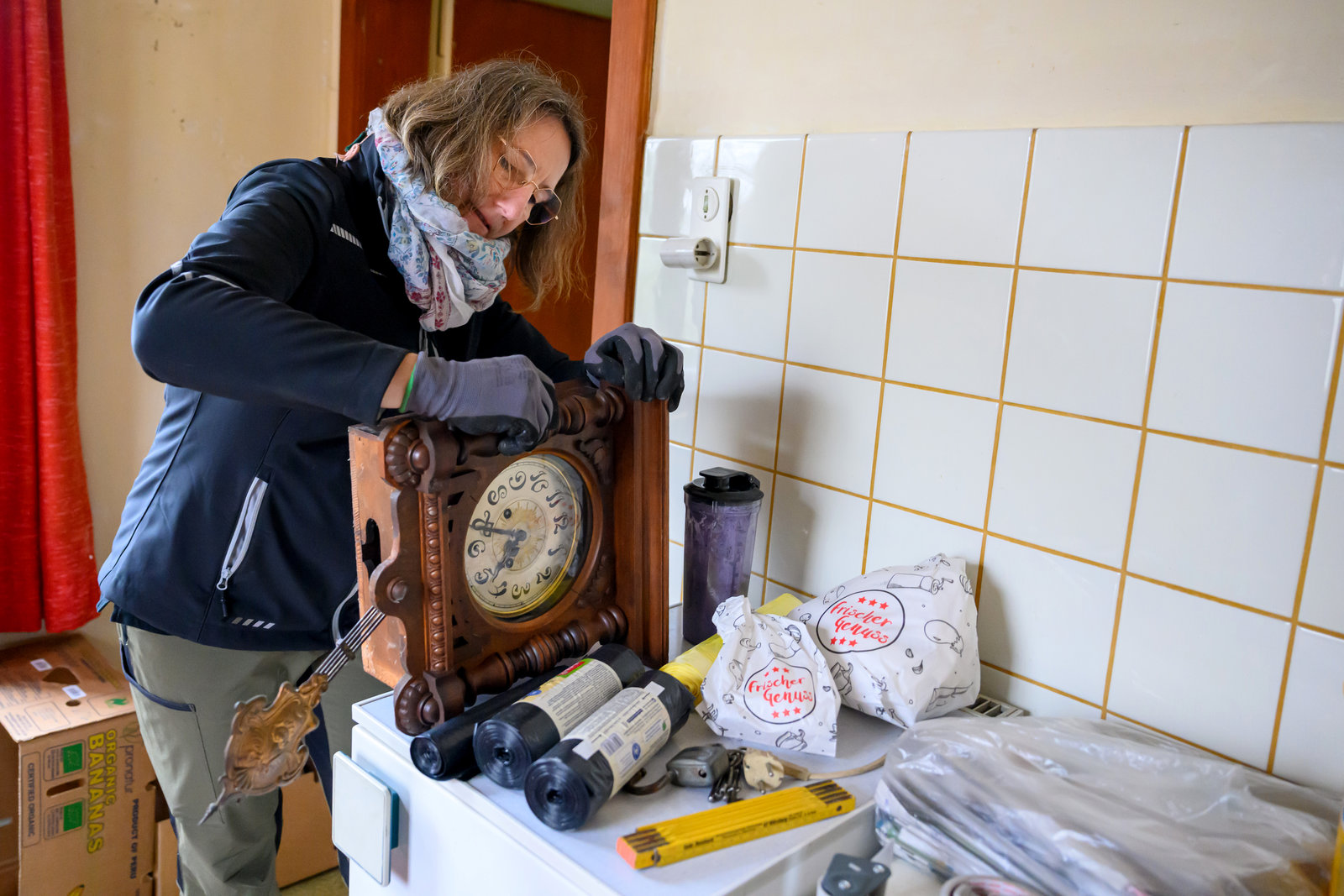 Eine Frau hat eine alte Walduhr in der Hand.