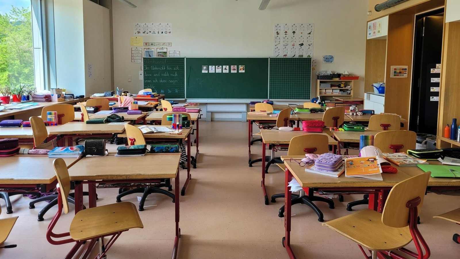 Ein Klassenzimmer einer Grundschule. Vorne ist eine große Tafel angebracht.