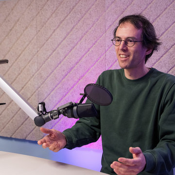 Wissenschaftler André Galli steht im Studio, spricht und gestikuliert.