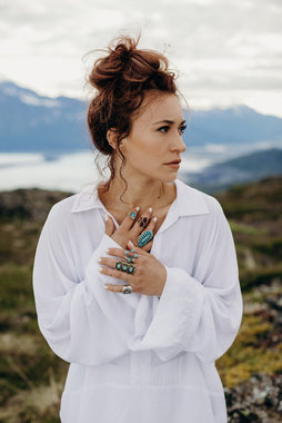 Lauren Daigle steht vor Feldern und eine See