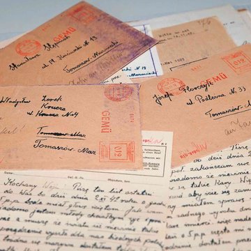 Auf dem Bild sind handgeschriebene Abschiedsbriefe von Häftlingen aus den NS-Todeszellen in Stadelheim zu sehen, sowie beschriftete Briefumschläge