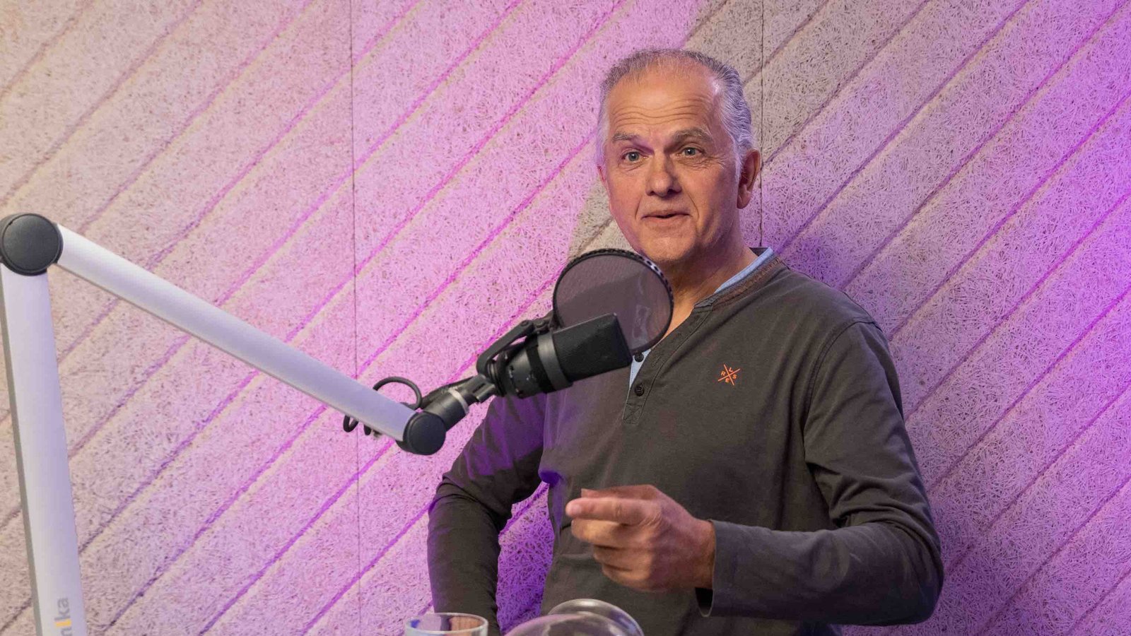 Hartmut Schott steht hinter einem Mikrofon.