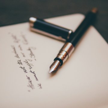 Handgeschriebener Brief auf dem ein Füllfederhalter liegt