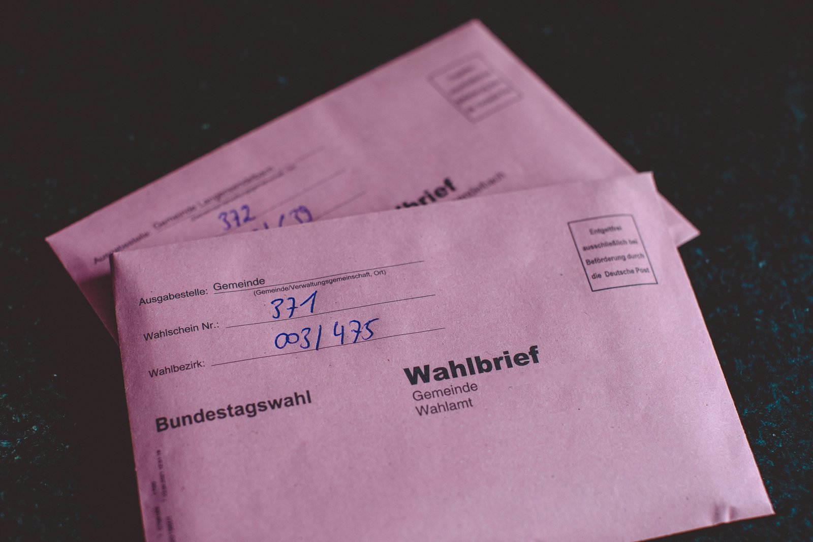 Zwei rosa Umschläge auf denen Wahlbrief steht