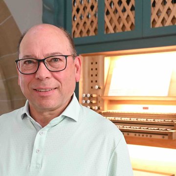 Das Foto zeigt Thomas Fritz. Der Mann steht in einer Kirche vor einer Orgel