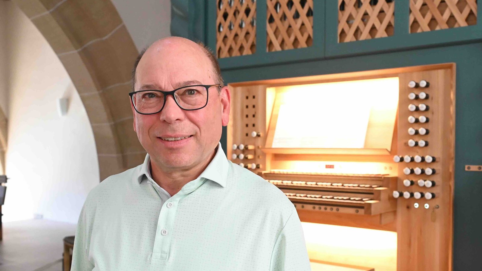 Das Foto zeigt Thomas Fritz. Der Mann steht in einer Kirche vor einer Orgel