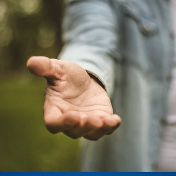 Ein Mann hält seine Hand einladend in die Kamera.