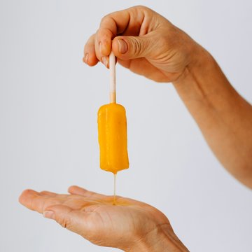 Schmelzendes Eis zwischen zwei Händen gehalten.
