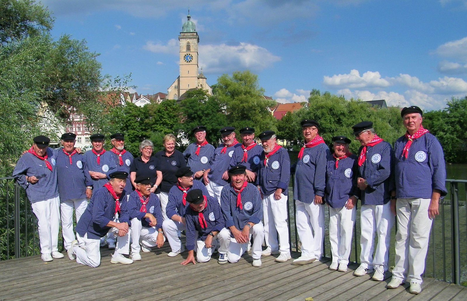 Shanty-Chor steht vor Fluss und Kirche