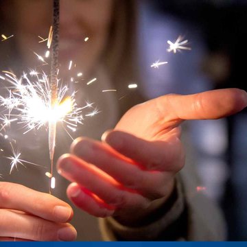 brennende Wunderkerze in der Hand gehalten.