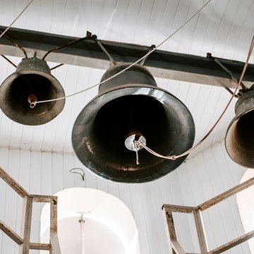 Vier Glocken hängen nebeneinander in einem Turm