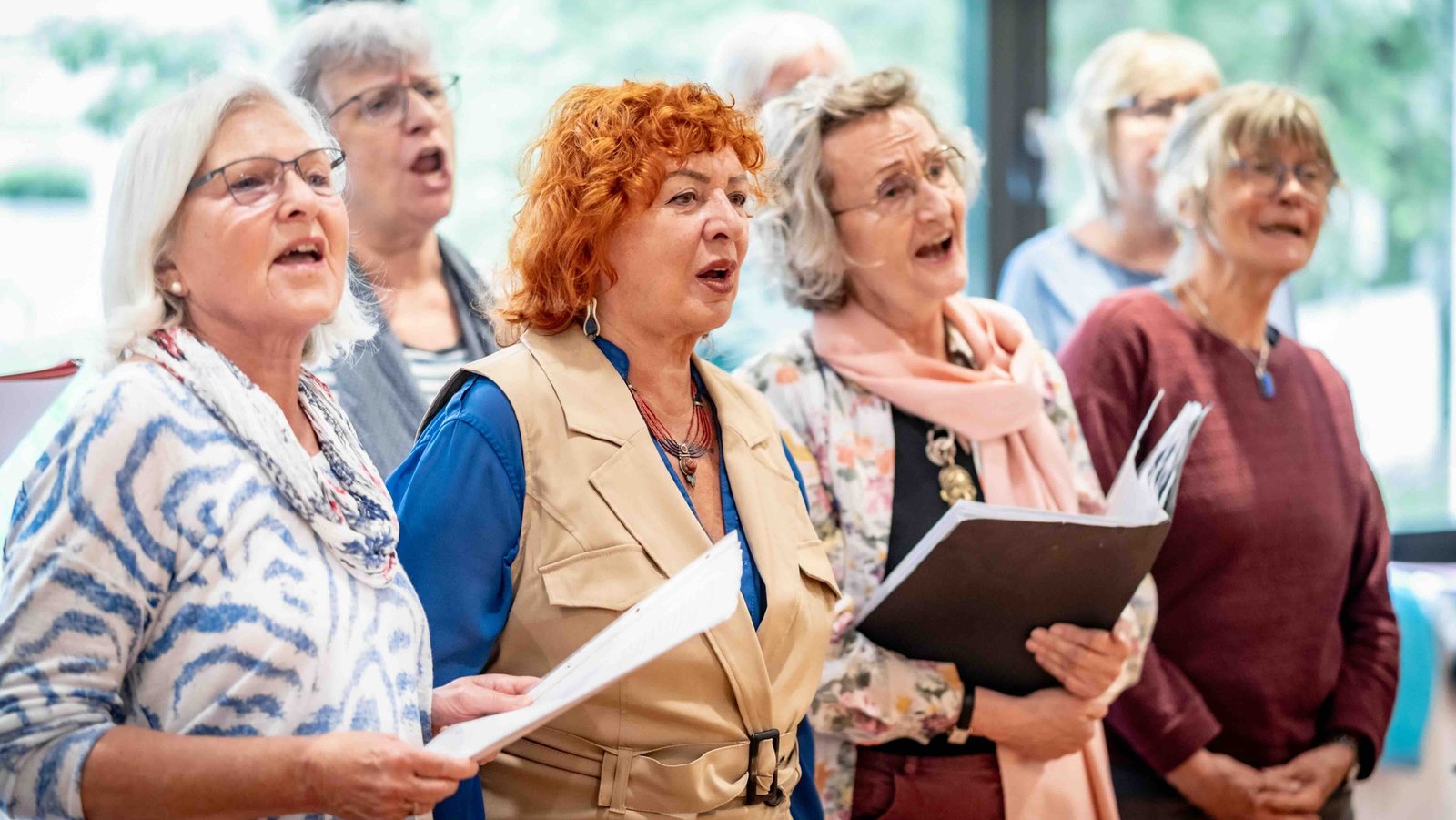 Eine Gruppe von älteren Frauen singt zusammen in einem Chor.