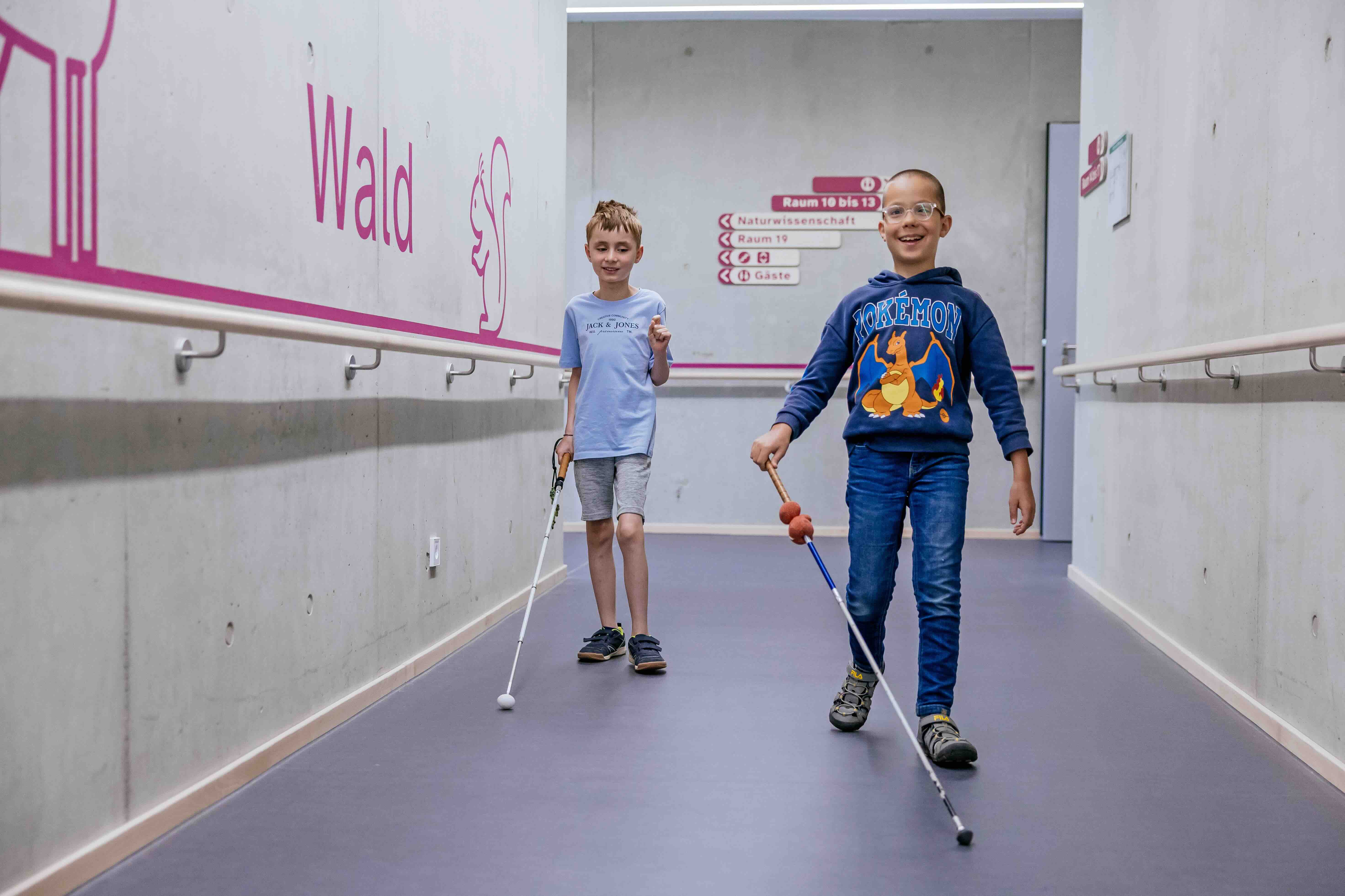 Michail und Gabriel laufen durch die Schule mit ihrem Blindenstock.