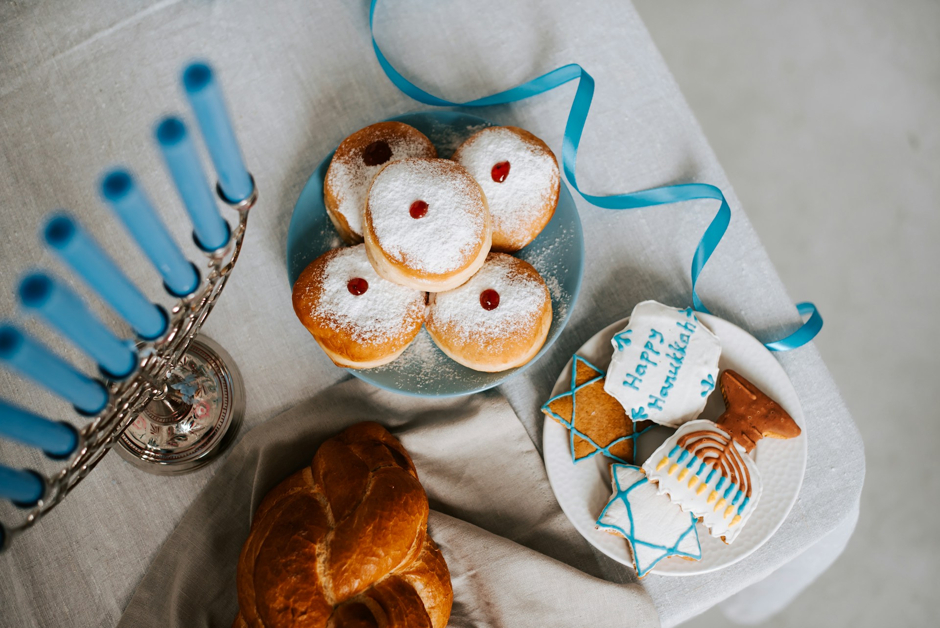 Gebäck auf dem "Happy Hanukkah" steht und ein siebenarmiger Leuchter mit Kerzen.