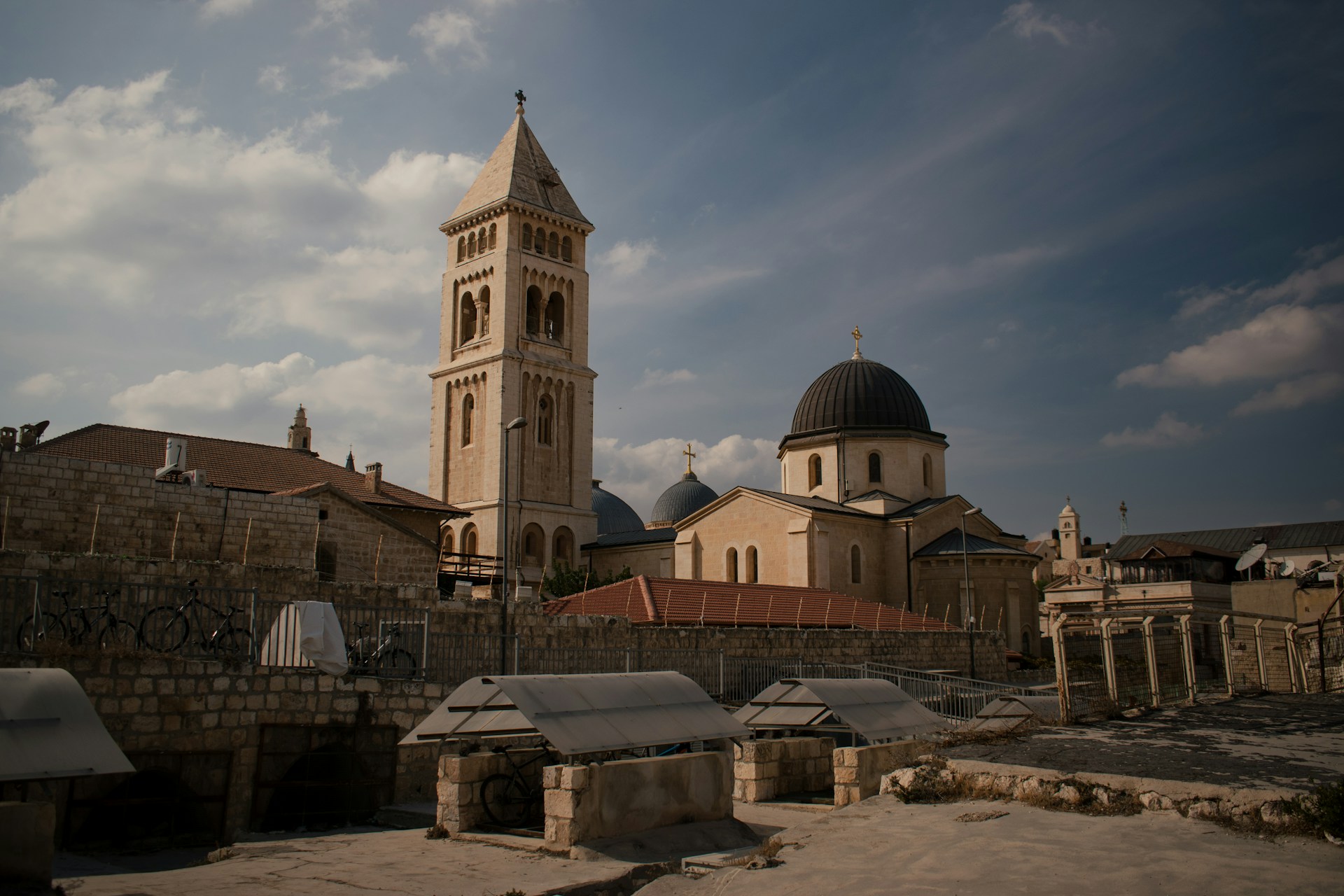 Das Foto zeigt die Erlöserkirche in Jerusalem bei Tag. Daneben ist eine Basilika mit Kuppeldach zu sehen.