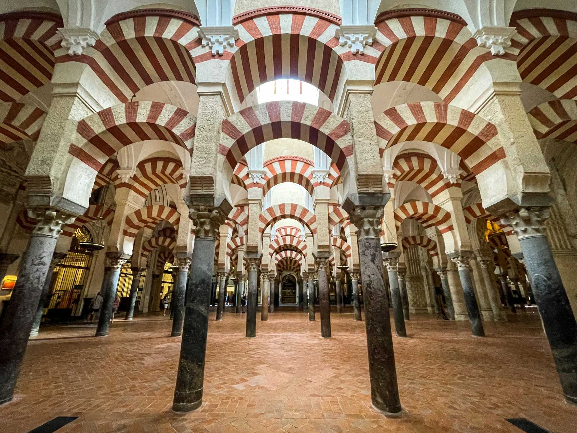 Das Innere der Mezquita Catedral in Cordoba: gestreifte Rundbögen und Säulen sind zu sehen.